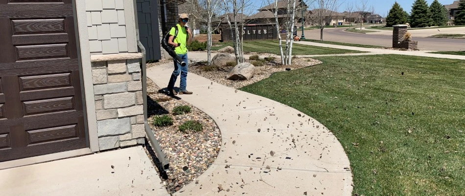 A professional blowing away debris for spring cleanup service for a customer in Harrisburg, SD.