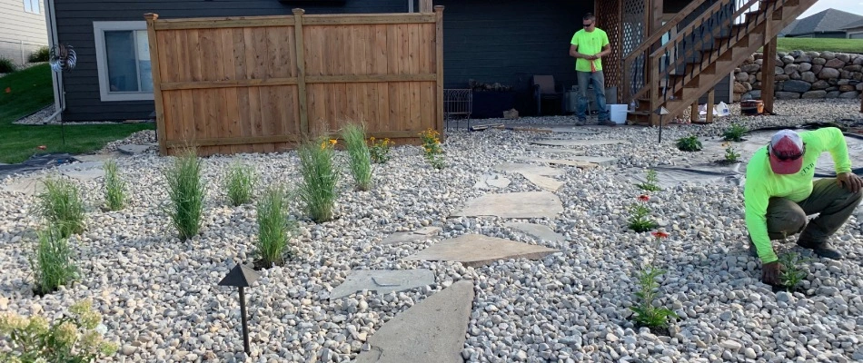 Professionals from The Yard Barbers installing rock ground coverings in Brandon, SD.