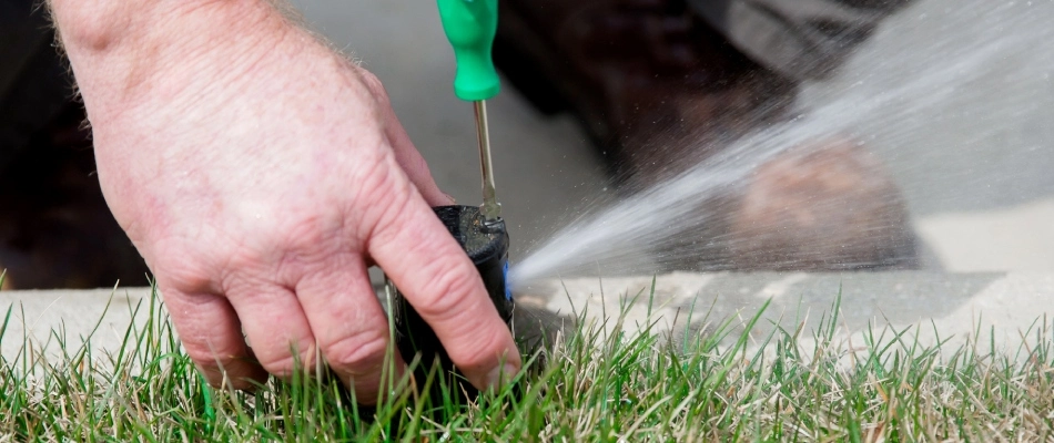 A specialist repairing a broken irrigations system for a customer in Sioux Falls, SD.